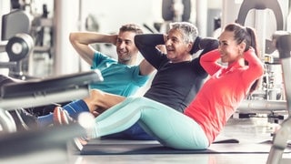 Drei Personen unterschiedlichem Alters machen Sport. Um die Knochen zu stärken und Osteoporose vorzubeugen, spielt Krafttraining eine entscheidende Rolle. Auch um einem Herzinfarkt vorzubeugen, ist Kraft- und Ausdauertraining wichtig.