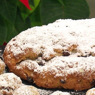 Quarkstollen mit Nüssen liegt auf einem Brett. Das Rezept besticht dadurch, dass man den Stollen gleich essen kann. 