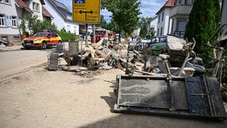 Aufräumarbeiten nach Unwetter, In den Vorgärten der Häuser stapeln sich Möbel, aufgequollene Türen und sonstiger Hausrat. Heftige Unwetter haben Straßen überflutet, Keller volllaufen und vor allem den Fluss Saalbach im Landkreis Karlsruhe extrem ansteigen lassen.  Unwetter haben 2024 nach Angaben der Versicherer in Deutschland weniger Schäden verursacht als im Jahr zuvor.