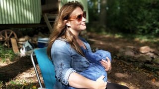 Eine Mutter stillt auf einer Bank ihr Baby. Nicht nur das Kind profitiert vom Stillen mit Muttermilch an der Brust, auch Mütter: Das Risiko für Brustkrebs und Fettstoffwechselstörungen etwa reduziert sich deutlich.