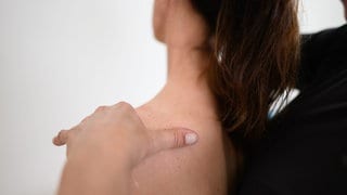 Eine Frau wird von einem Chiropraktiker am Rücken behandelt