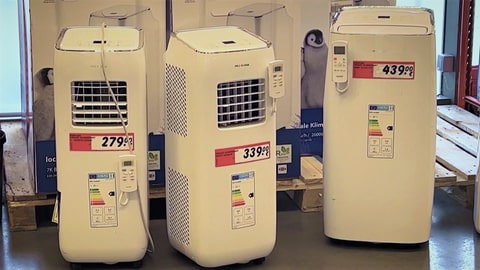 In einem Elektronikmarkt stehen drei mobile Klimaanlagen, sogenannte Monoblocks zum verkauft. Die Preisschilder zeigen, dass die drei Klimageräte zwischen 280 und 430 Euro kosten.