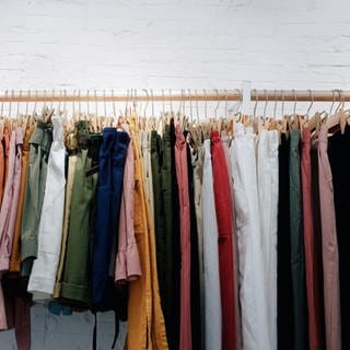 Kleidung an Kleiderstange - Woran erkennt man nachhaltige Kleidung?