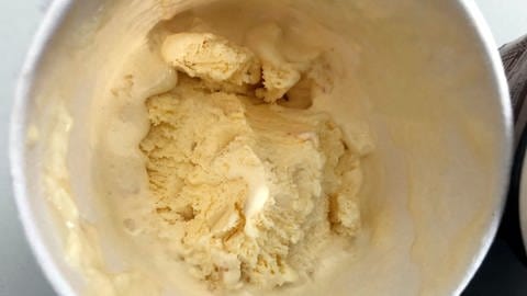 Vanilleeis im Eisbecher: Eiscreme schmilzt lecker und zart, wenn sie mit Milchfett angereichert ist, statt mit Pflanzenfett wie etwa Kokosfett.