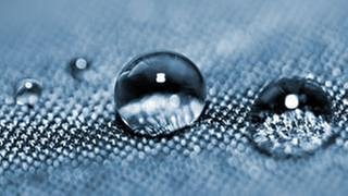 Wassertropfen perlen auf Gewebe ab